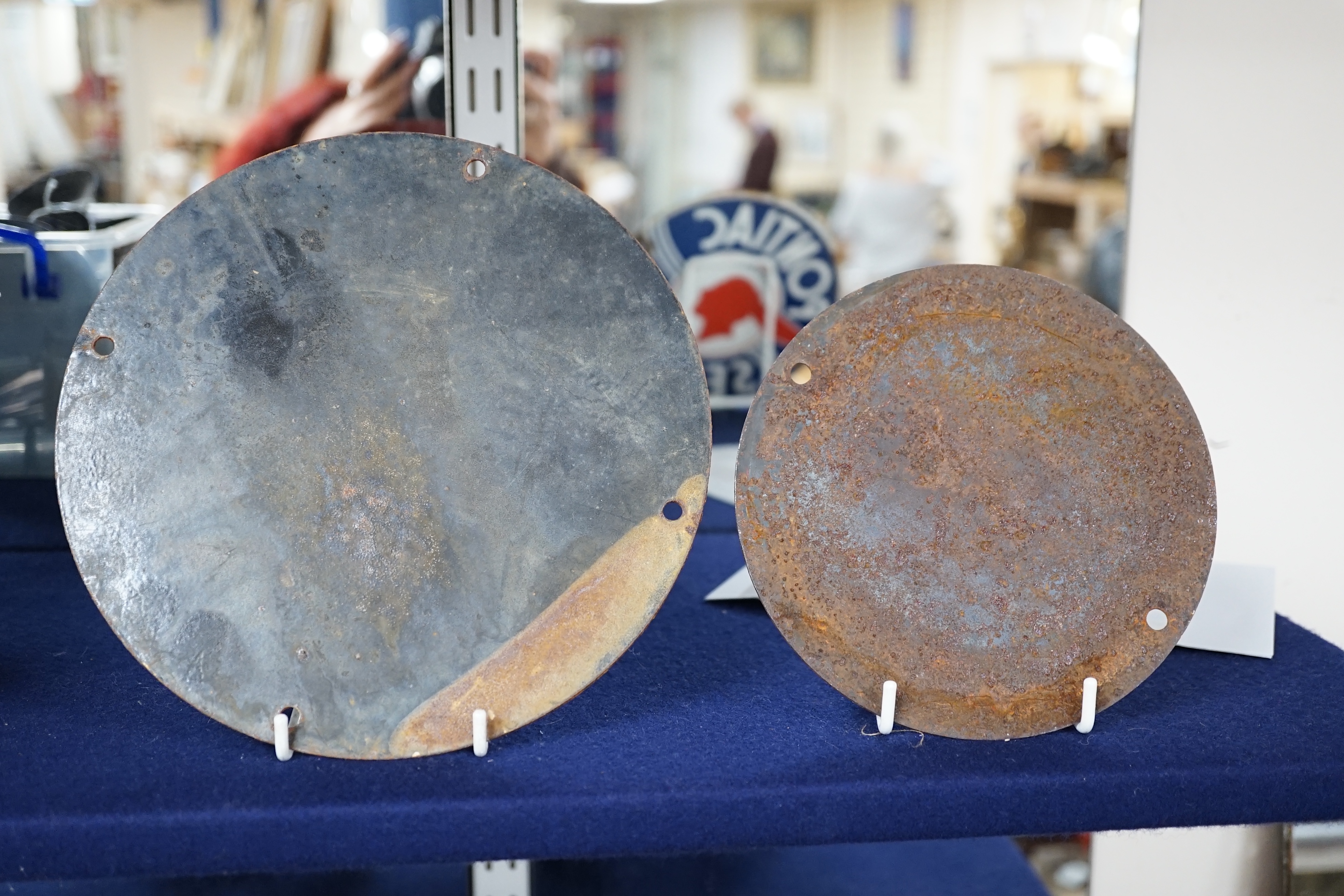 Automobilia interest; an early 20th century Esso enamel sign, diameter 20cm, and a Pontiac Service enamel sign, diameter 15cm. Condition fair to good, some chipping around the screw holes and surface rust to exposed meta